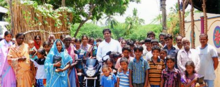 Ein junger indischer Priester freut sich über ein neues Moped für seine Arbeit