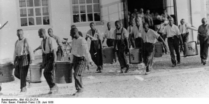 Dachau, Konzentrationslager Schutzhaftlager Dachau.- Häftlinge Töpfe tragend.